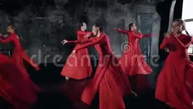 一群穿红色连衣裙的漂亮女孩一起在一个演播室里跳舞，集体舞蹈排练。